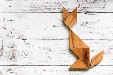 Tangram bulmacanın eski beyaz ahşap zemin üzerinde kedi şeklinde