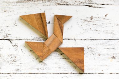 Eski Beyaz ahşap arka plan (Konsept özgürlük, yeni bir deneyim için üzerinde kuş şekli uçan tangram bulmacanın)
