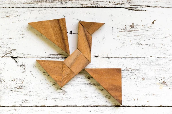 Eski Beyaz ahşap arka plan (Konsept özgürlük, yeni bir deneyim için üzerinde kuş şekli uçan tangram bulmacanın)