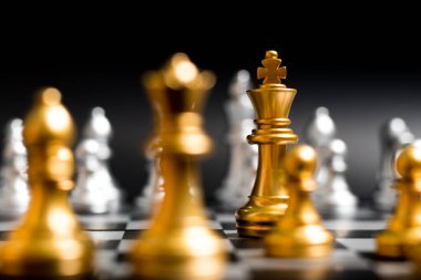 Altın Kral ve siyah arka plan (Konsept şirket stratejisi, iş zafer veya karar için başka bir gümüş takım satranç oyun karşısında takım)