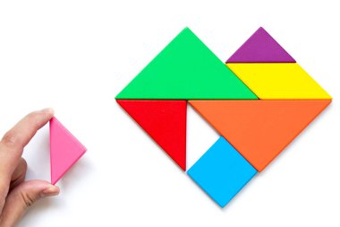 Kalp şeklinde ahşap tangram yapbozu. Beyaz arka planda tamamlanmak için bekleyin.