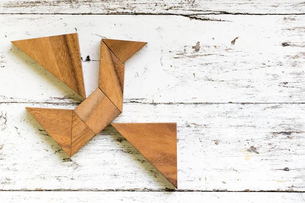 Tangram puzzle in flying bird shape on old white wood background (Concept for freedom, new experience)