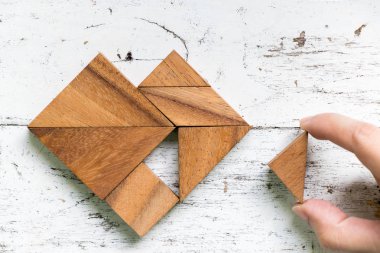 Eski Beyaz ahşap arka plan (aşk kavramı üzerinde kalp şekli yerine getirmek için tangram bulmacanın parçası düzenlenen kadın)