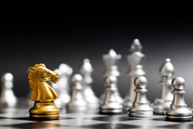 Siyah arka plan (konsept şirket stratejisi, iş zafer veya karar için başka bir gümüş takım ile satranç oyun yüzüne altın at)