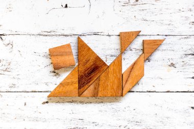 Tangram bulmacanın içinde düşen adam eski beyaz tahta arka plan (iş kriz kavramı üzerinde şekil)