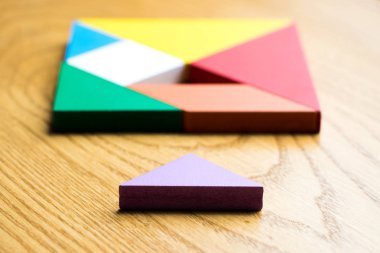 Tangram bulmacanın komple ahşap arka plan üzerinde bekleyin kare şeklinde