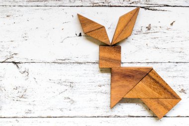 Tangram bulmacanın eski beyaz ahşap zemin üzerinde tavşan şeklinde