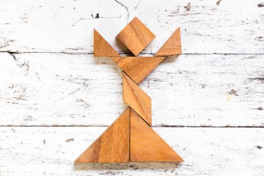 Tangram bulmacanın kız şekil eski beyaz ahşap arka plan üzerinde şarkı içinde