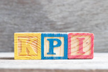 Renk mektup blok içinde kelime KPI (önemli performans göstergesi kısaltma) ahşap arka plan üzerinde