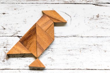 Tangram bulmacanın eski beyaz ahşap zemin üzerinde kuş şeklinde