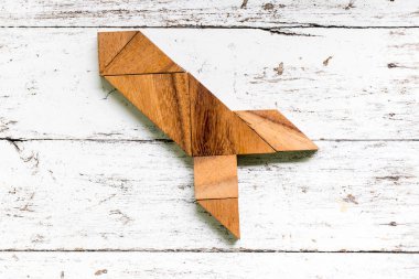 Tangram bulmacanın eski beyaz ahşap zemin üzerinde füze ya da roket şeklinde