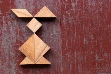 Kırmızı eski ahşap arka plan üzerinde tavşan şeklinde bulmaca Tangram 