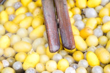 İpek makaralama için vintage yöntemi ve sıcak su arka planda sarı ve beyaz koza kapandı