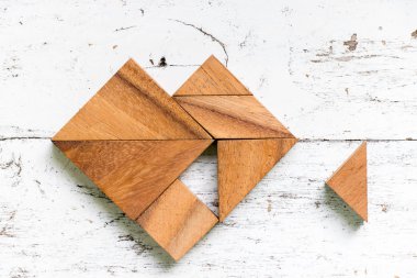 Tangram bulmacanın yerine getirmek veya eski beyaz ahşap arka plan üzerinde tamamlamak için bekleyin kalp şeklinde