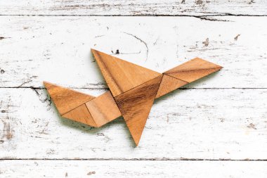 Eski Beyaz ahşap arka plan üzerinde uçak şekil uçan bulmaca Tangram