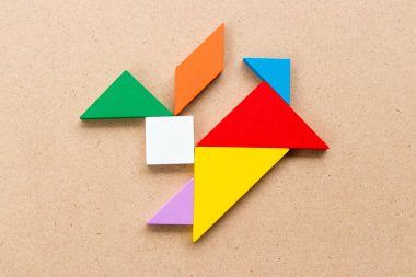Renk tangram bulmacanın ahşap arka plan üzerinde tavşan şeklinde