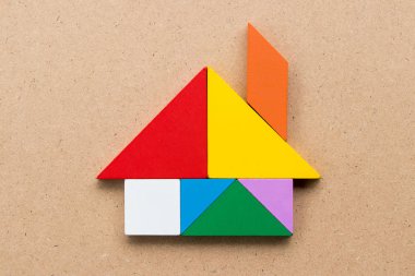 Renk tangram bulmacanın ahşap arka plan üzerinde ev şeklinde