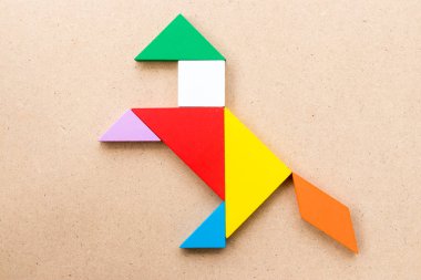 Renk tangram bulmacanın ahşap arka plan üzerinde heyecan verici at şeklinde