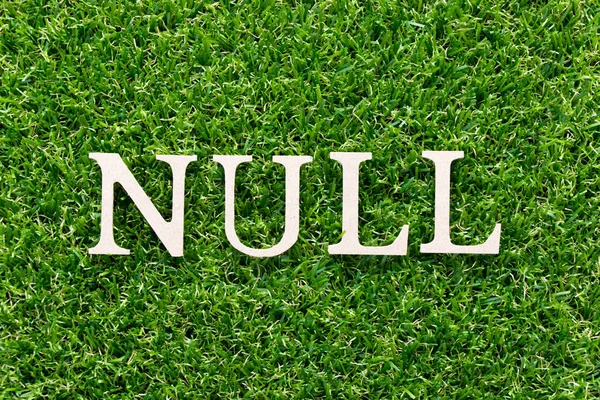 人工の緑の草の背景に Null Word で木製アルファベット — ストック写真