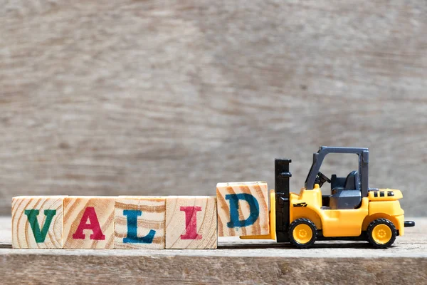 Spielzeug Gabelstapler Halten Buchstabenblock Vervollständigen Wort Gültig Auf Holz Hintergrund — Stockfoto