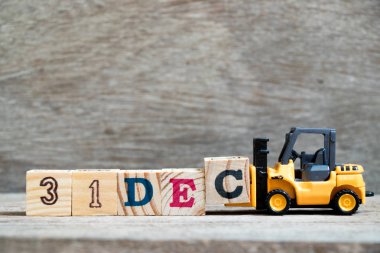 Oyuncak forklift tutun blok c tamamlamak için ahşap arka plan (takvim tarihi 31 Aralık ayındaki konsepti üzerinde 31 Aralık kelime)