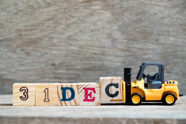 Oyuncak forklift tutun blok c tamamlamak için ahşap arka plan (takvim tarihi 31 Aralık ayındaki konsepti üzerinde 31 Aralık kelime)