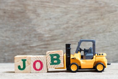 Oyuncak forklift tutun ahşap arka plan üzerinde kelime iş tamamlamak için mektup B blok