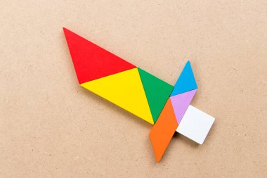 Renk tangram bulmacanın ahşap arka plan üzerinde kılıç şeklinde