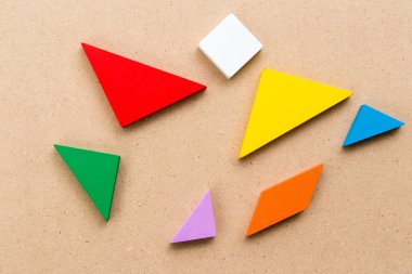 Renk tangram bulmacanın beklemek-e doğru tahta arka plan üzerinde tam şekil