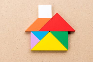 Renk tangram bulmacanın ahşap arka plan üzerinde ev şeklinde