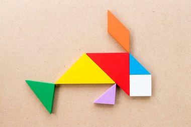 Ahşap arka plan üzerinde balık şekil yüzme içinde renk tangram bulmacanın