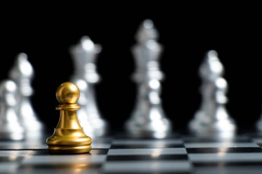Altın piyon satranç parça yüz siyah arka plan (Şirket Stratejisi, iş karar ve karşılaşma sorunu için konsept üzerine gümüş takım ile)