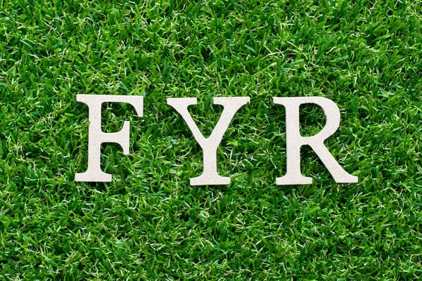 Wood alphabet in word FYR (abbreviation of for your reference) on artificial green grass background