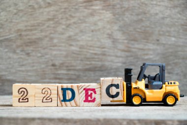 Oyuncak forklift tutun blok c tamamlamak için ahşap arka plan (takvim tarihi 22 Aralık ayındaki konsepti üzerinde 22 Aralık kelime)