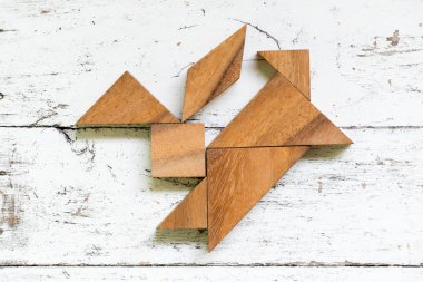 Tangram bulmacanın tavşan şekil üzerinde eski beyaz tahta arka plan atlama içinde