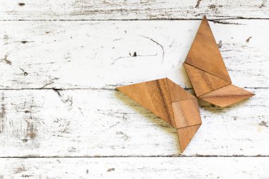 Eski Beyaz ahşap zemin üzerinde kelebek şeklinde bulmaca Tangram