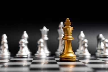 Altın Kral satranç parça siyah arka plan (Konsept şirket stratejisi, iş zafer veya karar için başka bir gümüş takım ile yüz)