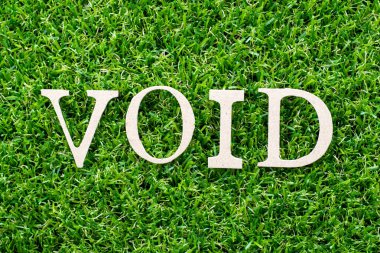 Wood letter in word void on artificial green grass background clipart