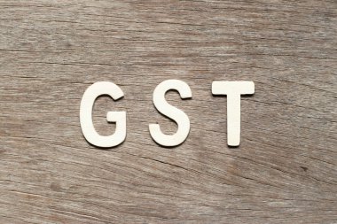 Alfabe harf kelime Gst (kısaltma mal ve hizmet vergisi) ahşap arka plan üzerinde