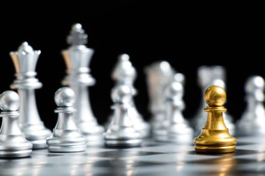 Altın piyon satranç parça yüz siyah arka plan (Şirket Stratejisi, iş karar ve karşılaşma sorunu için konsept üzerine gümüş takım ile)