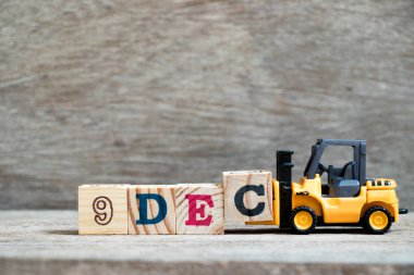 Oyuncak forklift tutun blok c tamamlamak için ahşap arka plan (takvim tarihi 9 Aralık ayındaki konsepti üzerine 9 Aralık kelime)