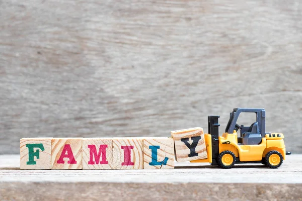 Spielzeug Gabelstapler Halten Buchstabenblock Wortfamilie Auf Holz Hintergrund Vervollständigen — Stockfoto