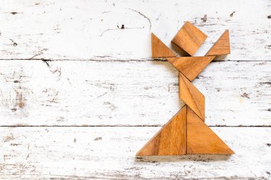 Tangram bulmacanın kız şekil eski beyaz ahşap arka plan üzerinde şarkı içinde