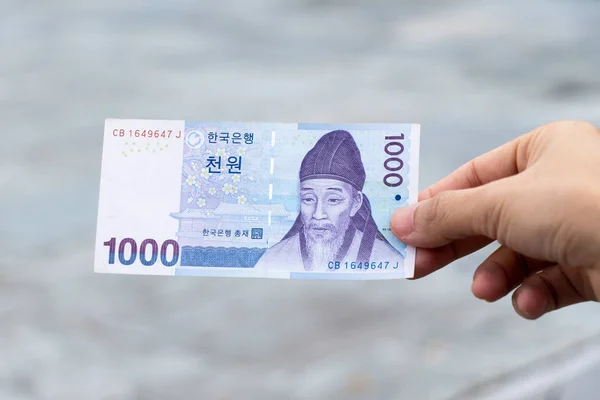 Człowiek Posiada Korea Południowa Banknot 1000 Wygrana Niewyraźne Tło — Zdjęcie stockowe