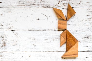 Tangram bulmacanın eski beyaz ahşap zemin üzerinde tavşan şeklinde