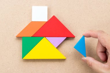 Üçgen parça ahşap arka plan (kavramı hakkında yapı rüya evi, mutlu bir aile veya ipotek yatırım için üzerinde ev şekli tamamlamak için bekleyin tangram bulmacanın renk)
