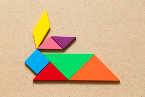 Renk tangram bulmacanın ahşap arka plan üzerinde tavşan şeklinde