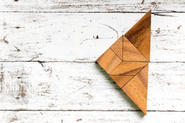 Tangram bulmacanın eski beyaz ahşap zemin üzerinde üçgen şeklinde