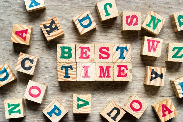 Letter block in word best time with another alphabet on wood background