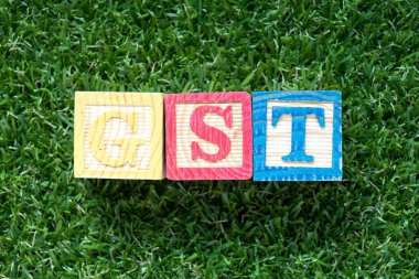 Renk ahşap blok içinde kelime Gst (kısaltma mal ve hizmet vergisi) suni yeşil çim zemin üzerine